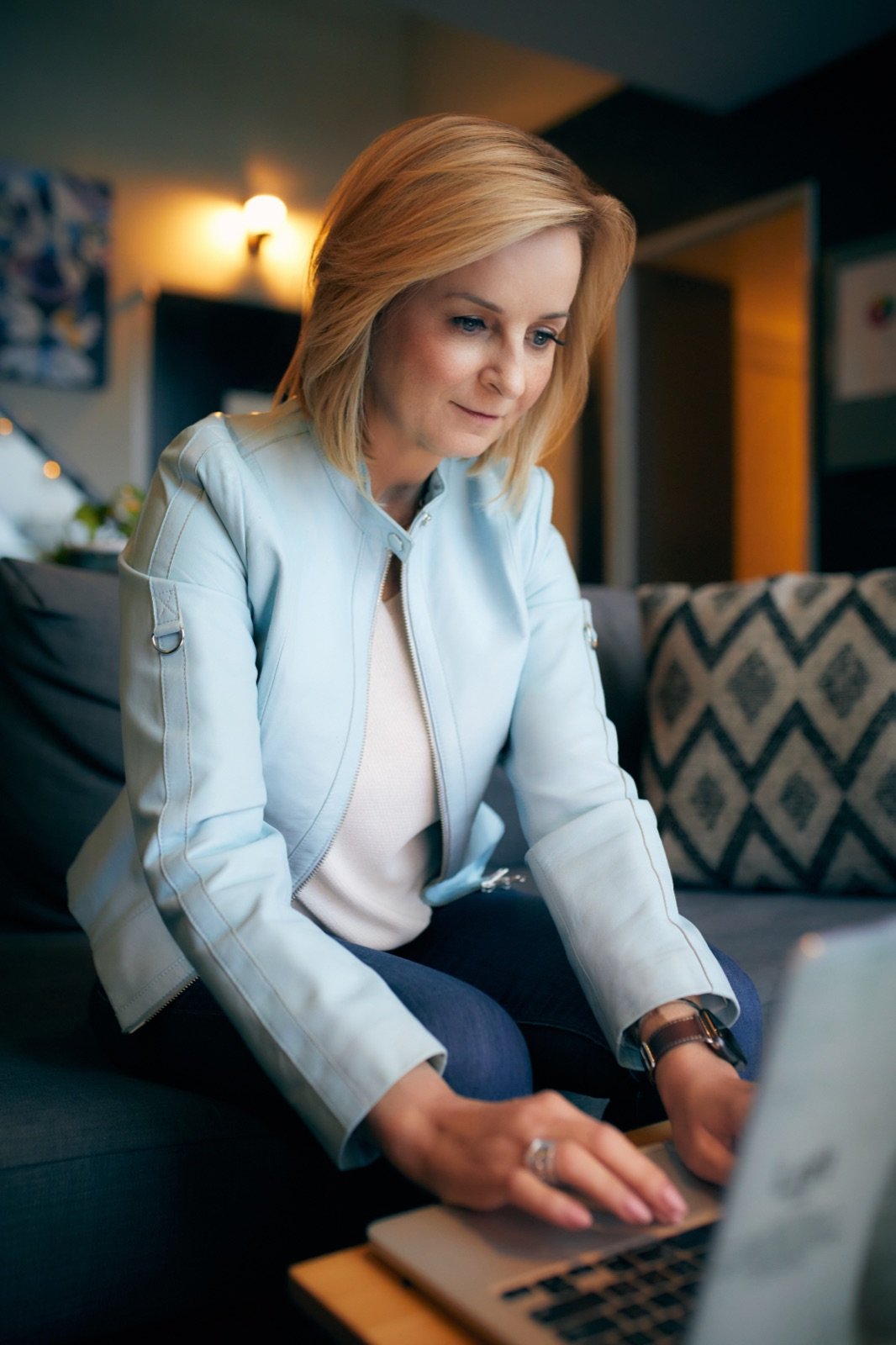 Tracy Quinton working on a laptop in a light blue blazer
