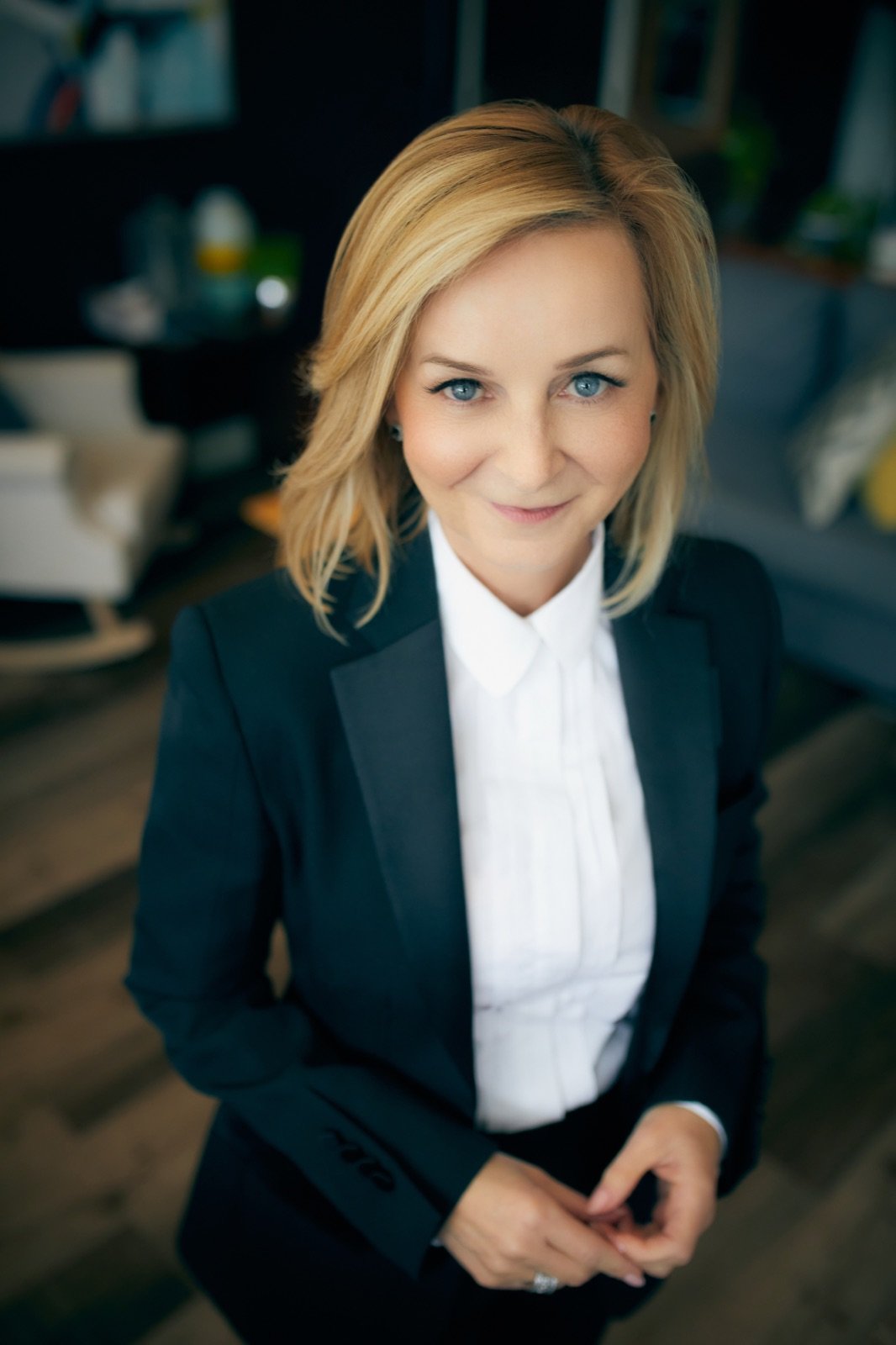 Tracy Quinton standing in a navy suit and white shirt, hands clasped